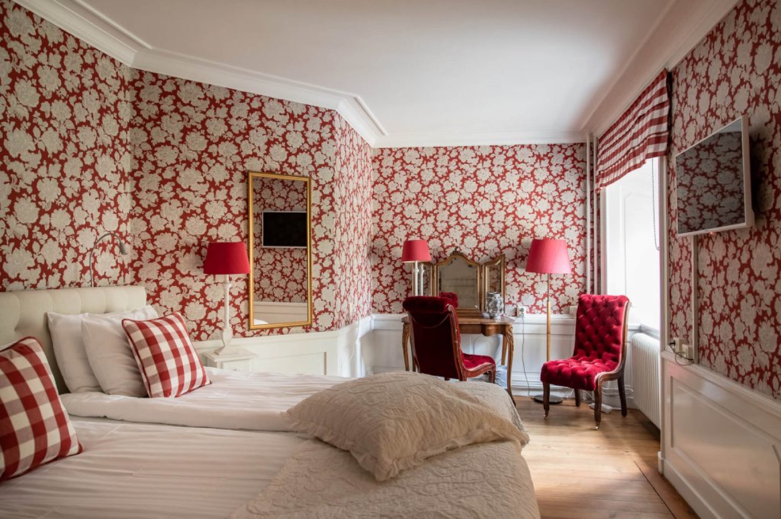 Hotellrum med röd blommig tapet